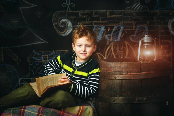 beautiful boy reading a book under the kerosene lamp