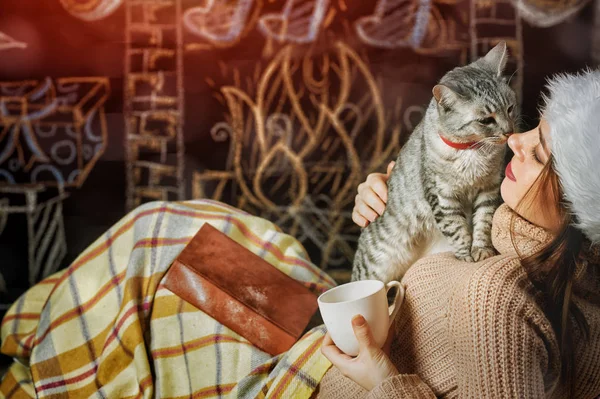 Menina brincando com um gato em um fundo de Natal — Fotografia de Stock