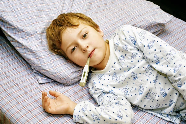 Άρρωστο αγόρι ξαπλωμένη στο κρεβάτι στο σπίτι — Φωτογραφία Αρχείου