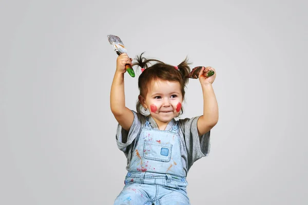 Menina na pintura brincando com os pincéis — Fotografia de Stock