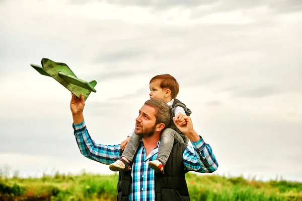 Father and son playing with toy plane