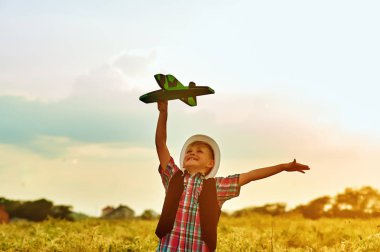 bir çocuk bir uçak ile oynuyor. Pilot olma hayalleri