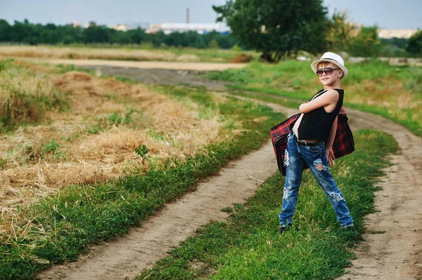 Elegantemente vestido chico en el campo con maleta — Foto de Stock