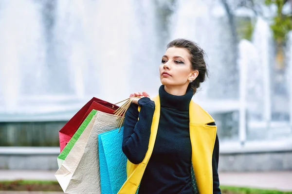 Atractiva linda chica con bolsas de compras en la ciudad —  Fotos de Stock