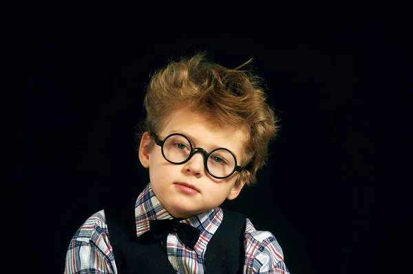 Retrato de un niño con gafas sobre un fondo oscuro —  Fotos de Stock