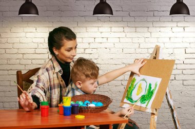 Anne ve oğlu Paskalya yumurtaları boya. Aile Paskalya için hazırlar