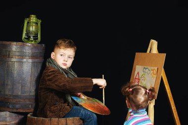 Çocuk sanatçı paleti ve fırçalar ile