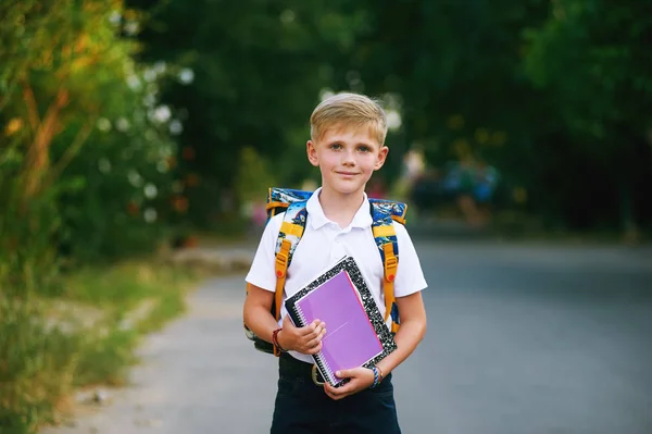 Портрет школьника на улице с рюкзаком и блокнотами — стоковое фото