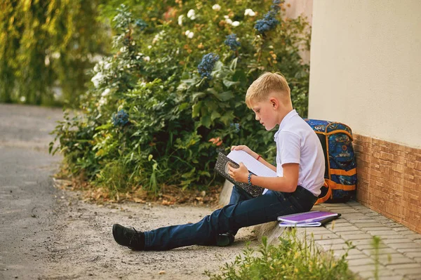 Портрет школьника на улице с рюкзаком и блокнотами — стоковое фото