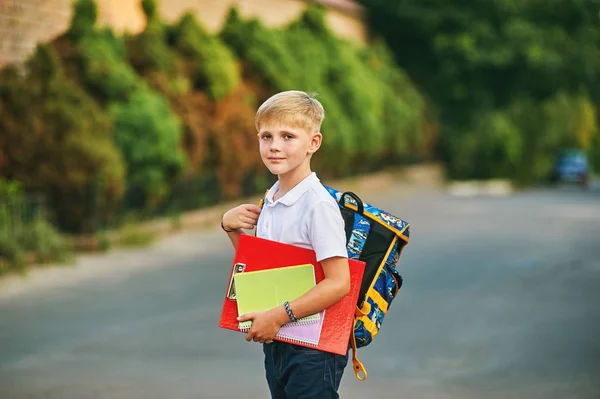 Porträtt av en skolpojke på gatan med en ryggsäck och bärbara datorer — Stockfoto