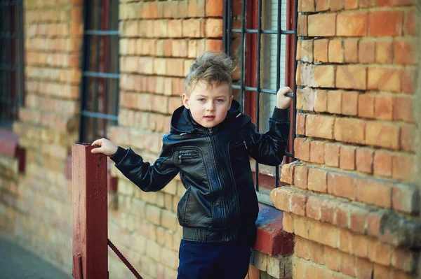 Lente portret van een jongen op een bakstenen muur — Stockfoto