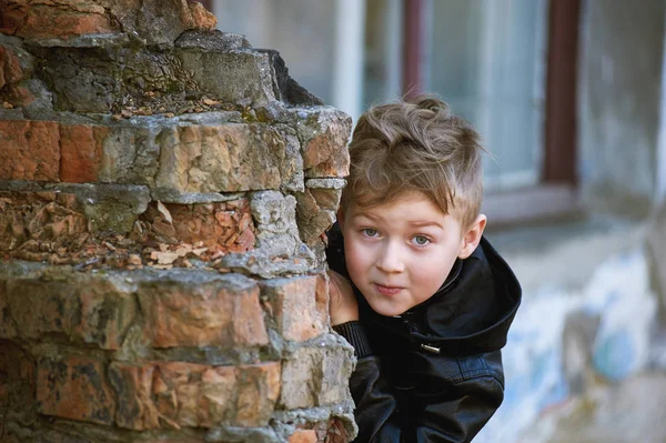 Een jongen kijkt uit achter een hoek. Kinder spellen — Stockfoto