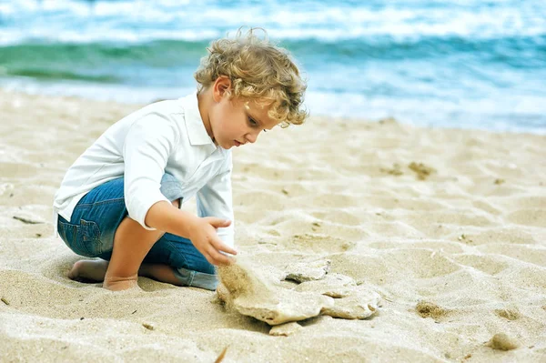 Niño jugando en la orilla del mar. El concepto de ocio infantil —  Fotos de Stock