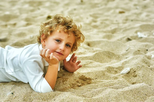 Niño jugando en la orilla del mar. El concepto de ocio infantil — Foto de Stock