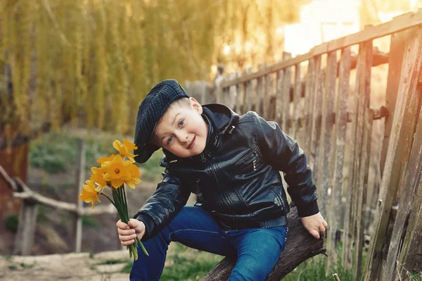 Elegante ritratto retrò di un ragazzo in campagna. Ragazzo con un mazzo di narcisi — Foto Stock