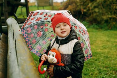 Yağmurda tutmak bir yumuşak oyuncak üzgün çocuk