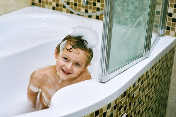 the boy takes a bath . Hygiene and body care