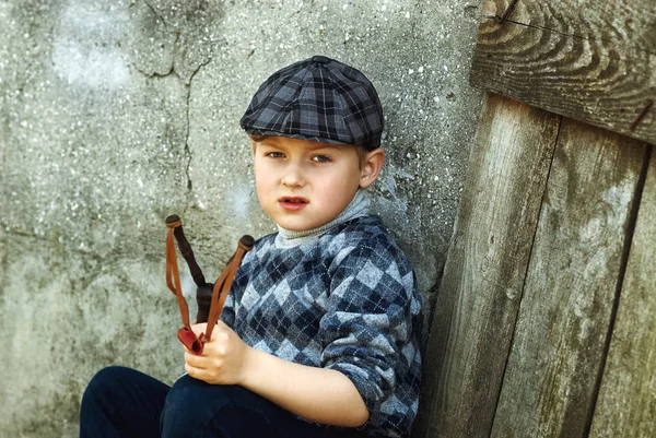 这个小男孩的帽子，用手中的弹弓恶霸 — 图库照片