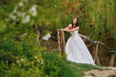 Çiçekli bahçe içinde genç güzel gelin. Düğün günü