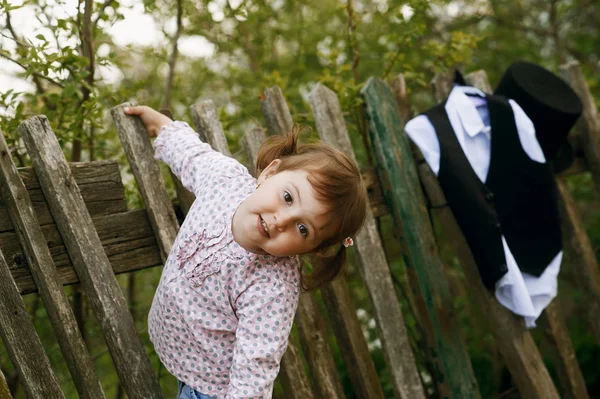 Маленькая девочка и старый деревенский забор — стоковое фото