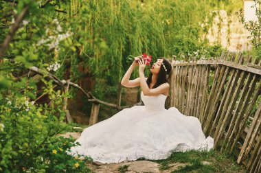 Çiçekli bahçe içinde genç güzel gelin. Düğün günü