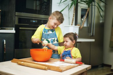 çocuklara anne yemek yemek yardım. Ev yapımı yiyecek ve küçük yardımcıları