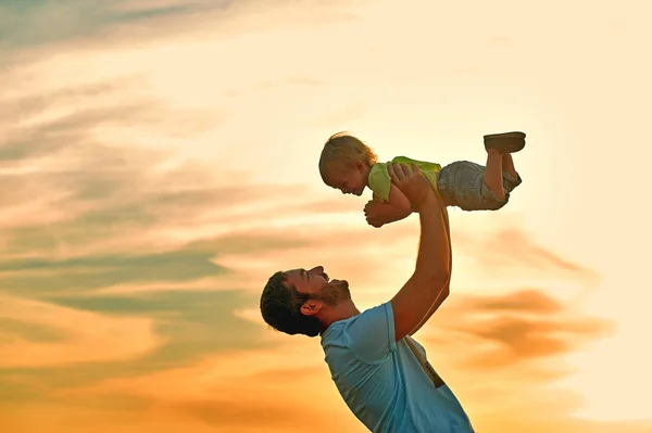 Happy father playing with son on sunset background .The concept of father 's day — стоковое фото