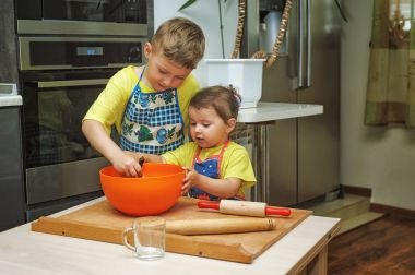 çocuklara anne yemek yemek yardım. Ev yapımı yiyecek ve küçük yardımcıları