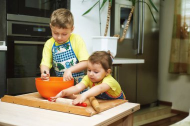 çocuklara anne yemek yemek yardım. Ev yapımı yiyecek ve küçük yardımcıları