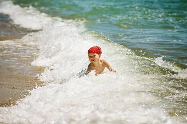Szczęśliwe dziecko bawiące się w morzu. Chłopiec zabawy odkryty. Letnie wakacje, a pojęcie zdrowego stylu życia. — Zdjęcie stockowe