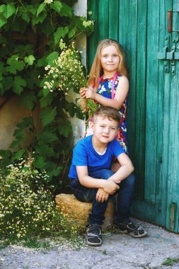 Güzel, zarif şekilde giyinmiş çocuk eski bir vintage kapıda. Çocuk dostluk kavramı