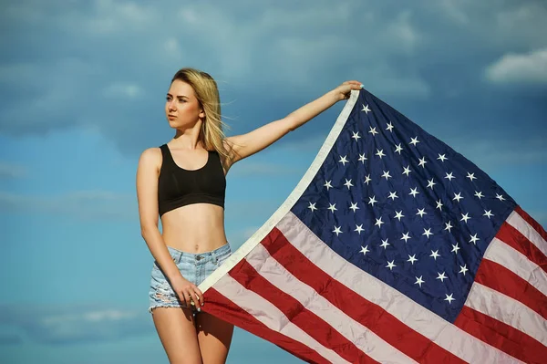 Girl with waving U.S. flag on blue sky background . — Stock Photo, Image