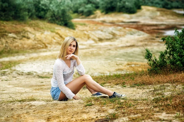 Όμορφη νεαρή γυναίκα που κάθεται στο έδαφος — Φωτογραφία Αρχείου