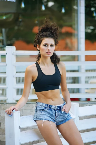 Een jong meisje van een sport Grondwet, in de zomer in de stad. Het concept van zomer-vrijetijdskleding — Stockfoto