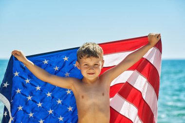 Amerika deniz kıyısında bayrağı çocukla