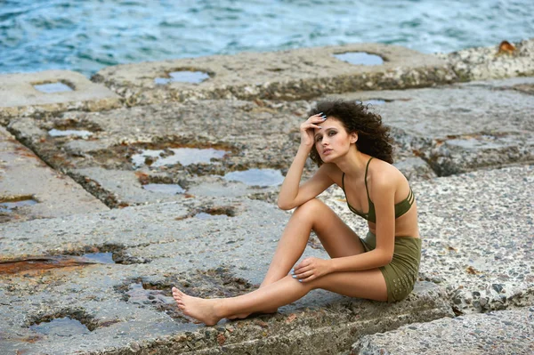 Mooie stijlvolle meisje zittend op de stenen platen. Het concept van zomer kleding — Stockfoto