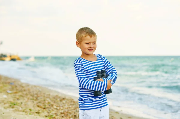 Un niño camina por la playa con prismáticos —  Fotos de Stock