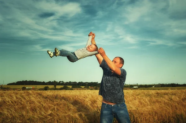 Gry z córka w polu, podrzucając go ojciec — Zdjęcie stockowe