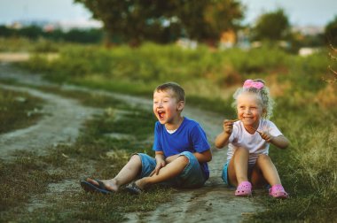 Yolda bir köpekle oynayan kız ve erkek