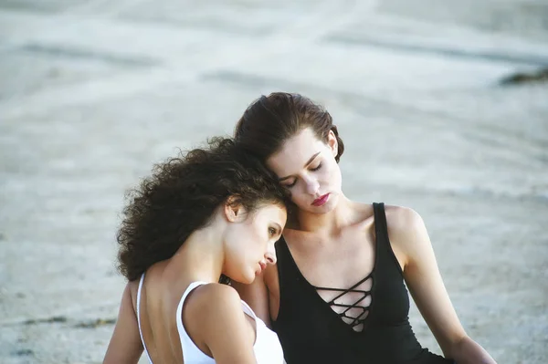 Dos chicas modelo posando acostado en la arena —  Fotos de Stock