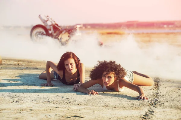 Meisje op de grond liggen. Op de achtergrond een gebroken motorfiets . — Stockfoto