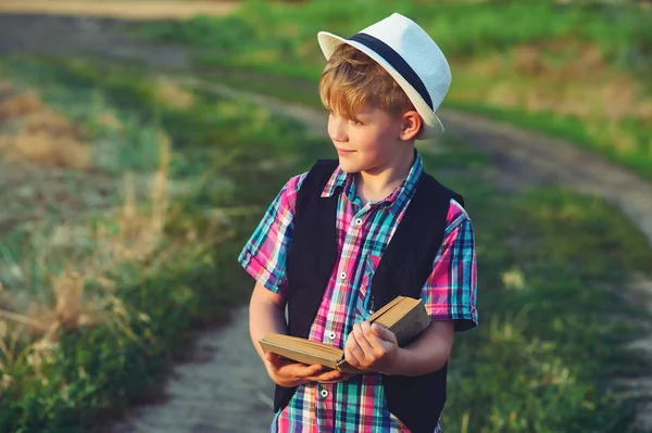 Jongen lezen van een boek in het veld. Het concept van het onderwijs van kinderen — Stockfoto