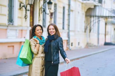 iki genç kadın ile alışveriş torbaları üzerinde bir şehir sokak 