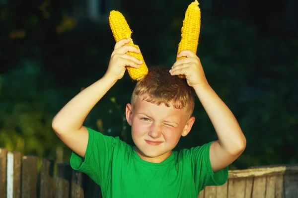 Garçon tenant du maïs dans ses mains.Alimentation saine naturelle — Photo