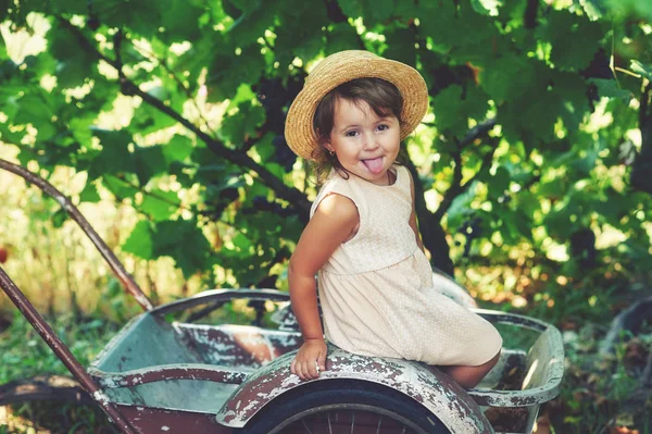 Bambina che mostra la lingua, seduta nel carrello — Foto Stock