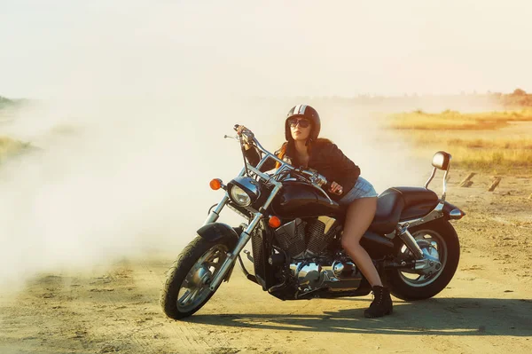 Attractive girl on a motorcycle on a dirt road — Stock Photo, Image