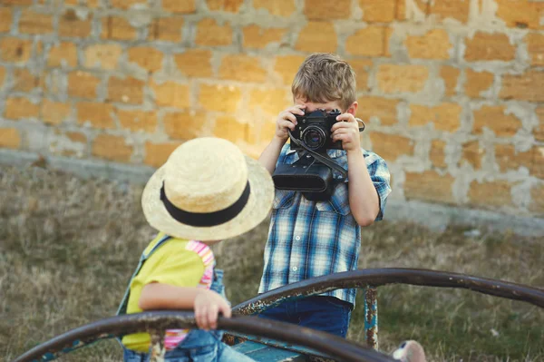 Hermano y hermana con una vieja cámara en la caminata. Joven fotógrafo alegre — Foto de Stock