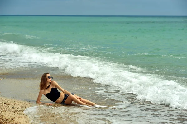 Jovem mulher na praia na costa — Fotografia de Stock