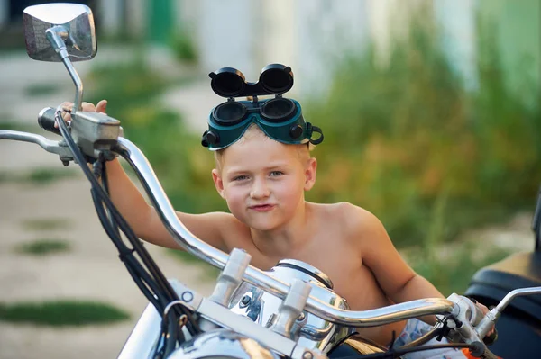 L'enfant est assis sur la moto de son père. Le rêve de devenir motard — Photo