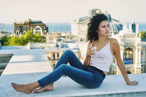 Jonge vrouw met morning kopje koffie zittend op het balkon — Stockfoto